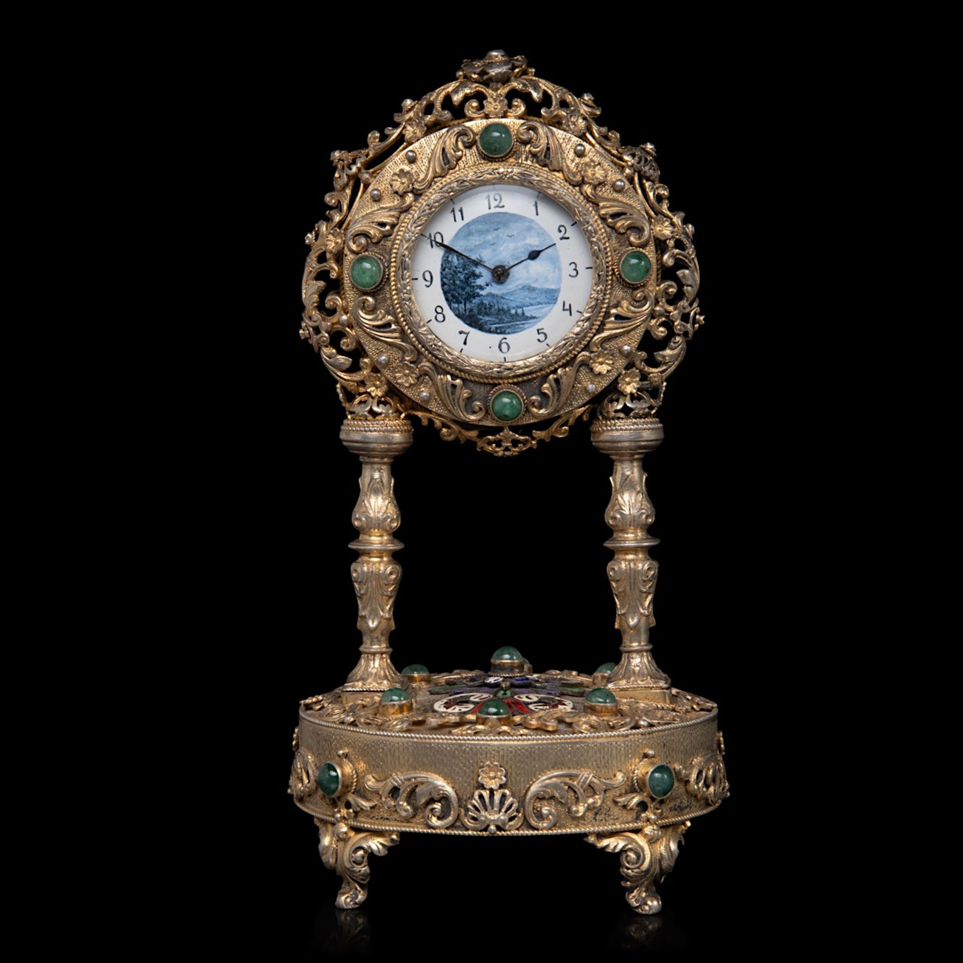 An Austrian gilt-silver and enamel clock with music box, decorated with semi-precious stones and mot