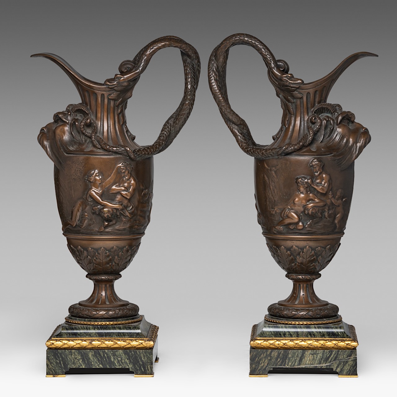 A pair of Neoclassical patinated bronze and marble ewers, in the Clodion manner, H 55 cm