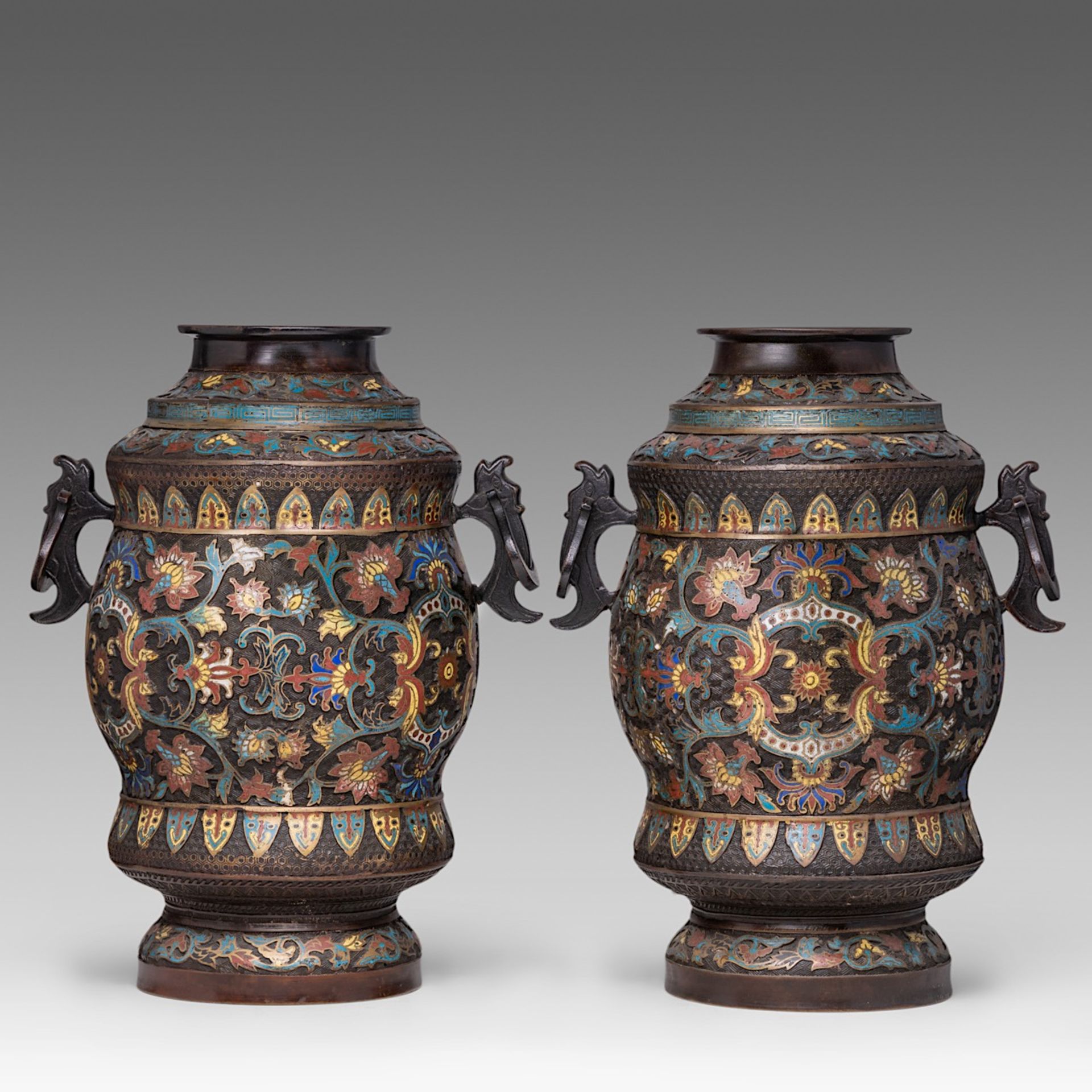 A pair of Japanese champleve enamelled bronze 'Scrolling Lotus' vases, paired with stylised dragon h