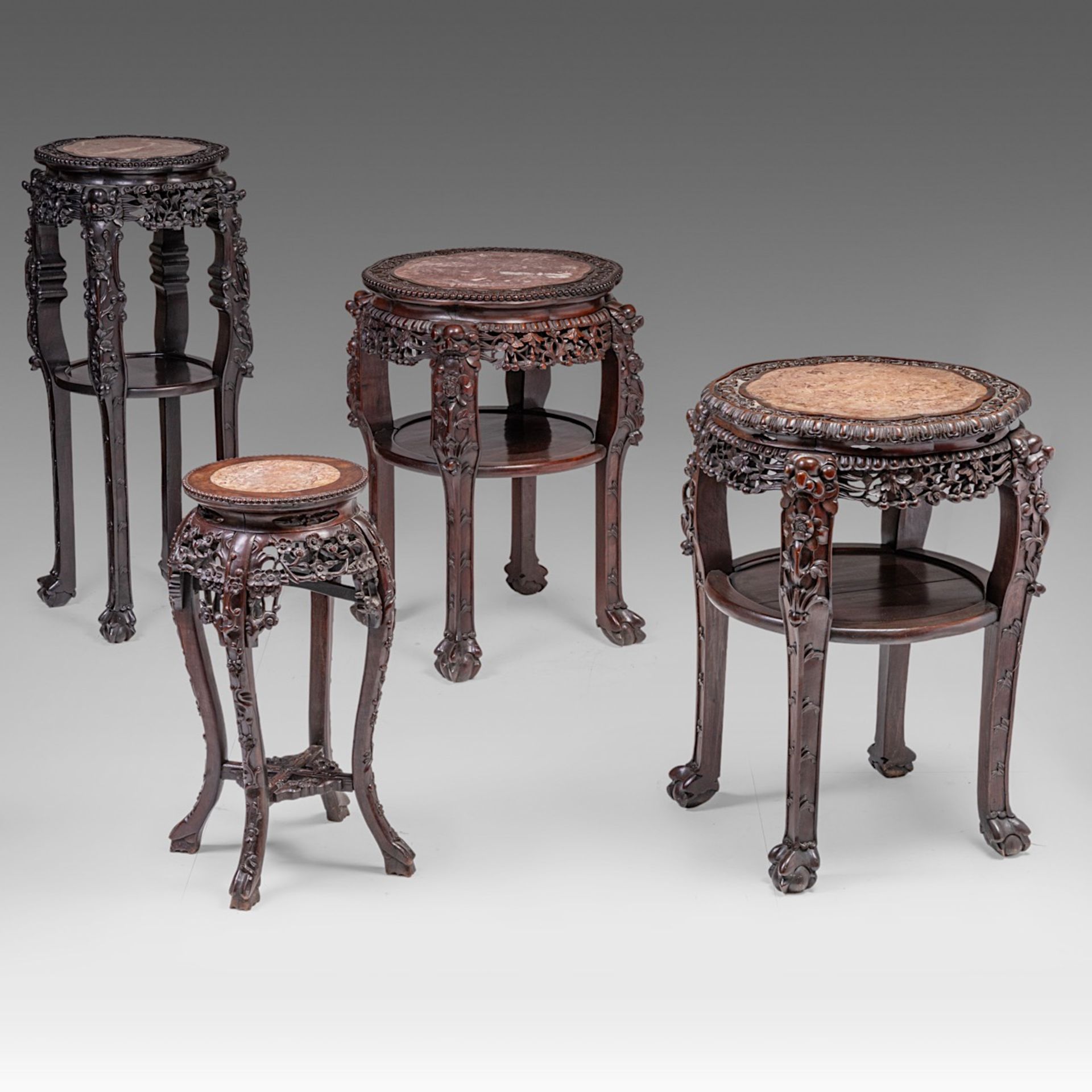 A small collection of four South Chinese carved hardwood bases, all with a marble top, late Qing, ta