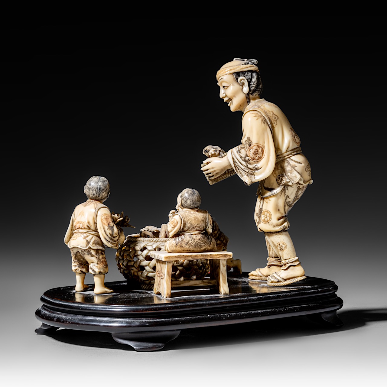 A walrus/sperm whale ivory okimono group of a family with bunnies, fixed on a black lacquered wooden - Image 4 of 10