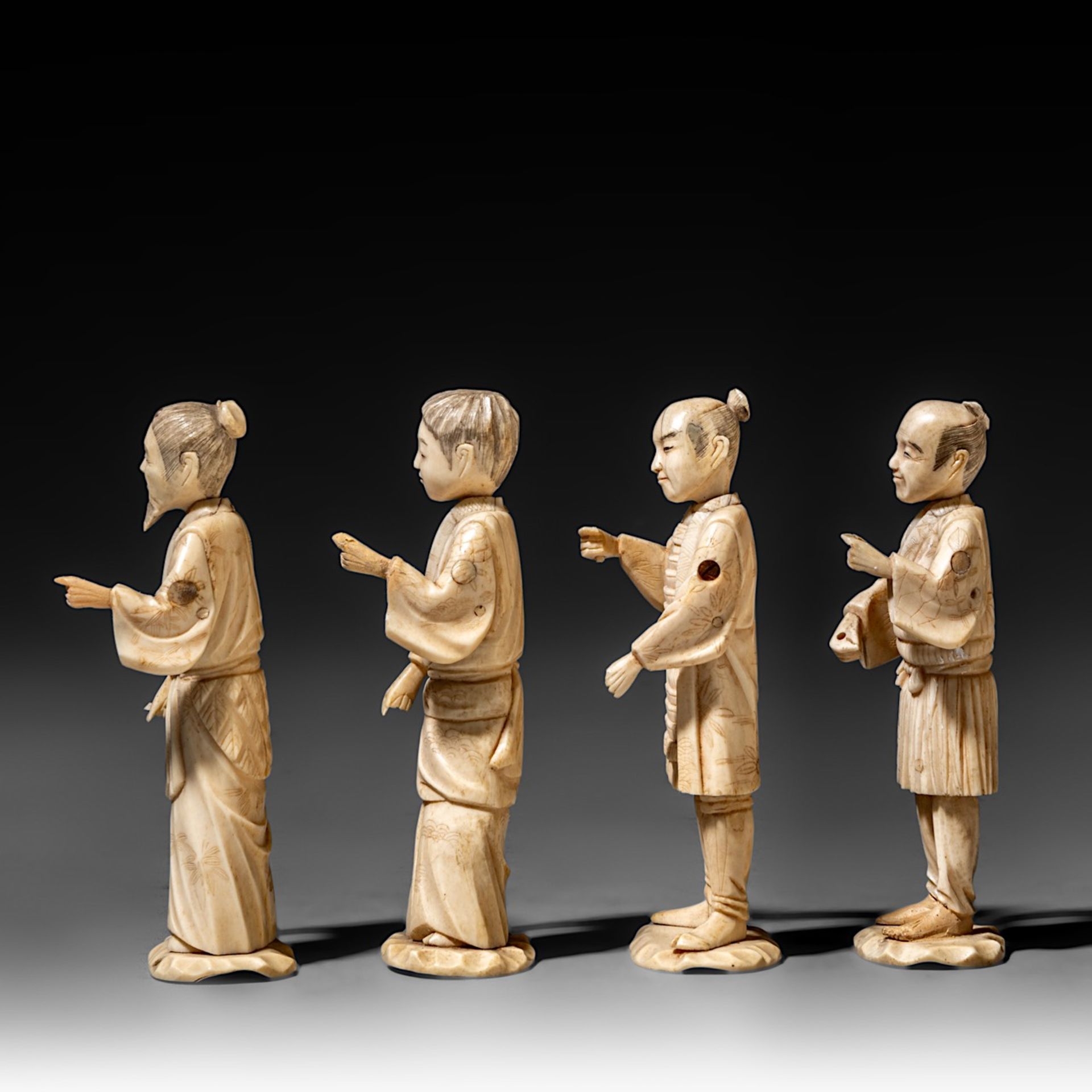Four Japanese bone okimono, the figures possibly representing different classes in society, on a woo - Image 3 of 7