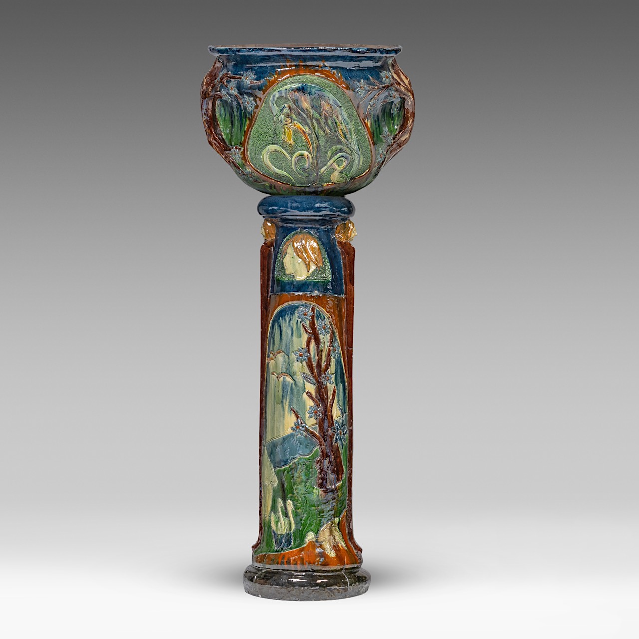 An imposing Art Nouveau polychrome earthenware cachepot on stand by the Caesens pottery manufactory,