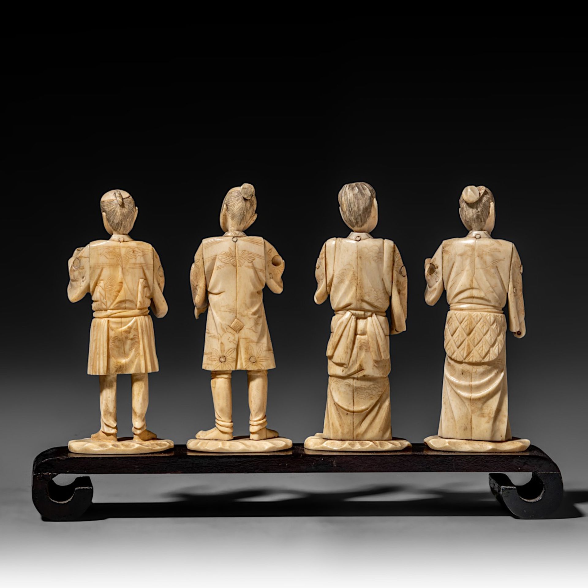 Four Japanese bone okimono, the figures possibly representing different classes in society, on a woo - Image 4 of 7