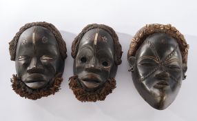 3 Gesichtsmasken, Dan, Liberia, Afrika, Holz, schwarzbraun patiniert, verschieden, teils Wollbehang