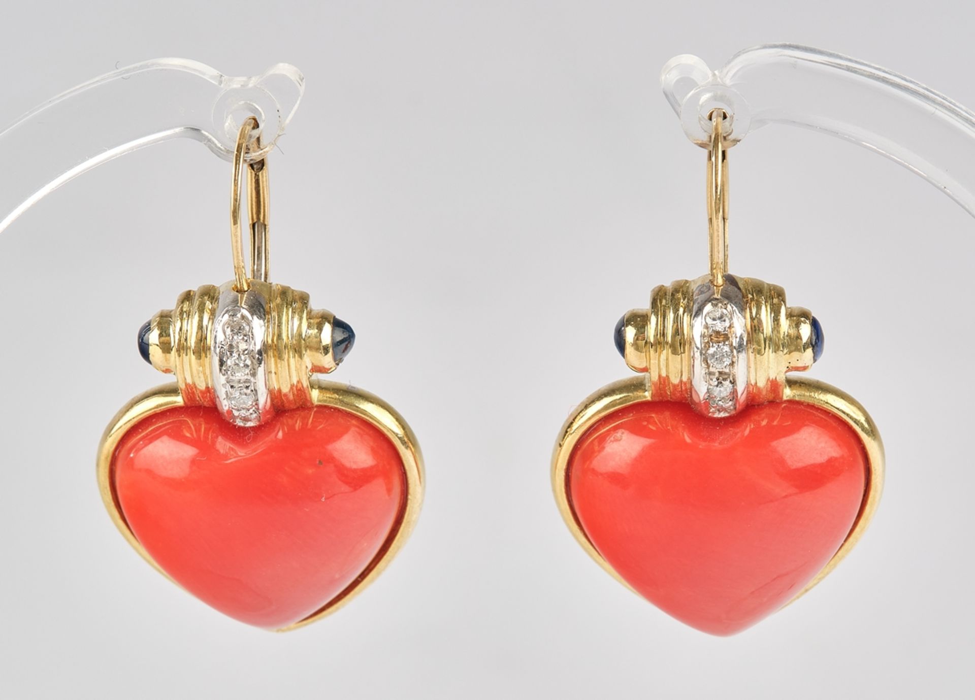 Pair of earrings, GG 750, 2 heart-shaped coral buttons, 4 small sapphire cabochons totalling ca. 0.
