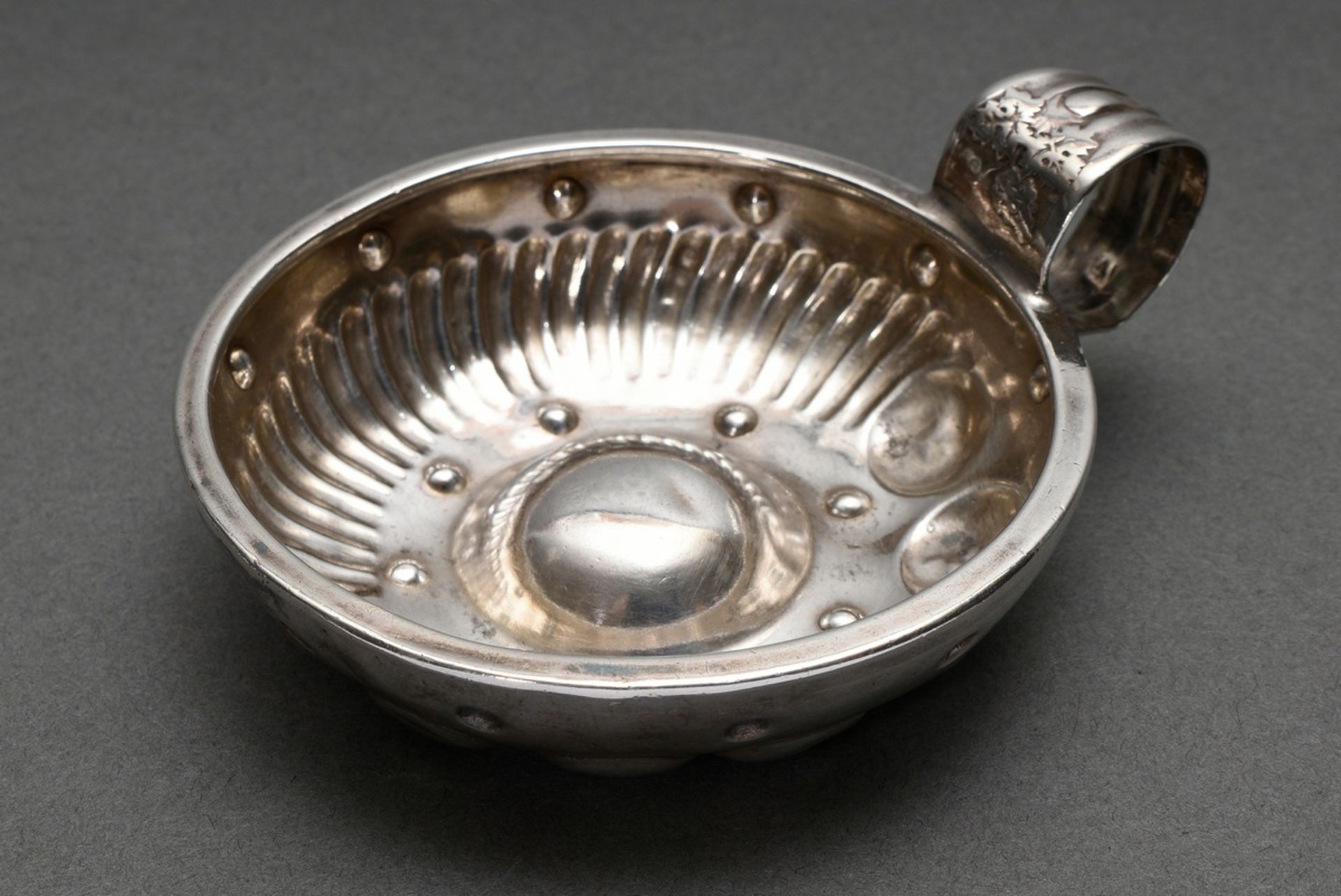 French Tastevin bowl with half humped and half fluted wall and wide ring handle with vine leaf reli