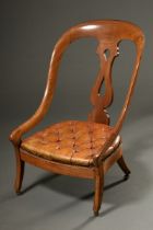 Low fireplace chair with capitoned cognac-coloured leather upholstery and curved backrest, England 