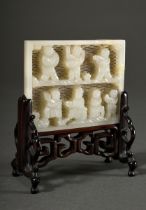 Light-coloured jade plaque "7 playing children" in relief on open-worked latticework, wooden stand,