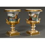 Pair of Empire porcelain krater vases with mascaron handles on an angular plinth, polychrome landsc