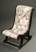 Low fireplace chair with capitoned upholstery in marbled fabric, painted black, England 19th c., h.