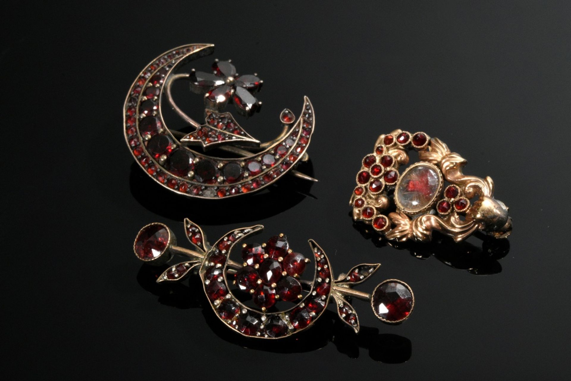 3 Various tombac and double needles with garnet, 19th century, one with small glass medallion, 2.5-