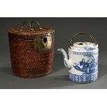 Round travel basket with floral brass fittings and latch, inside cylindrical porcelain jug with blu