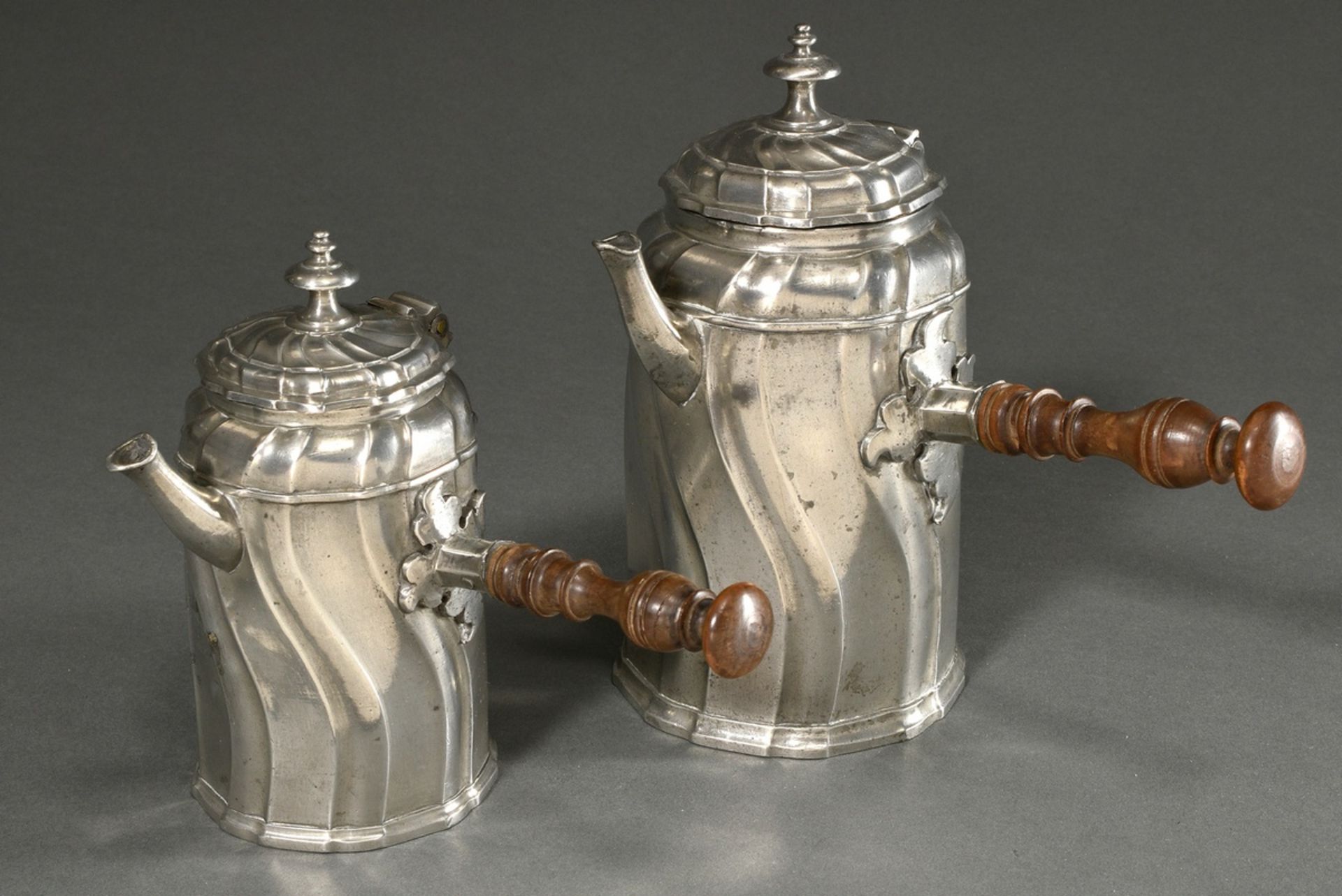2 various pewter chocolateries with conical body, curved features and wooden handles on the sides, 