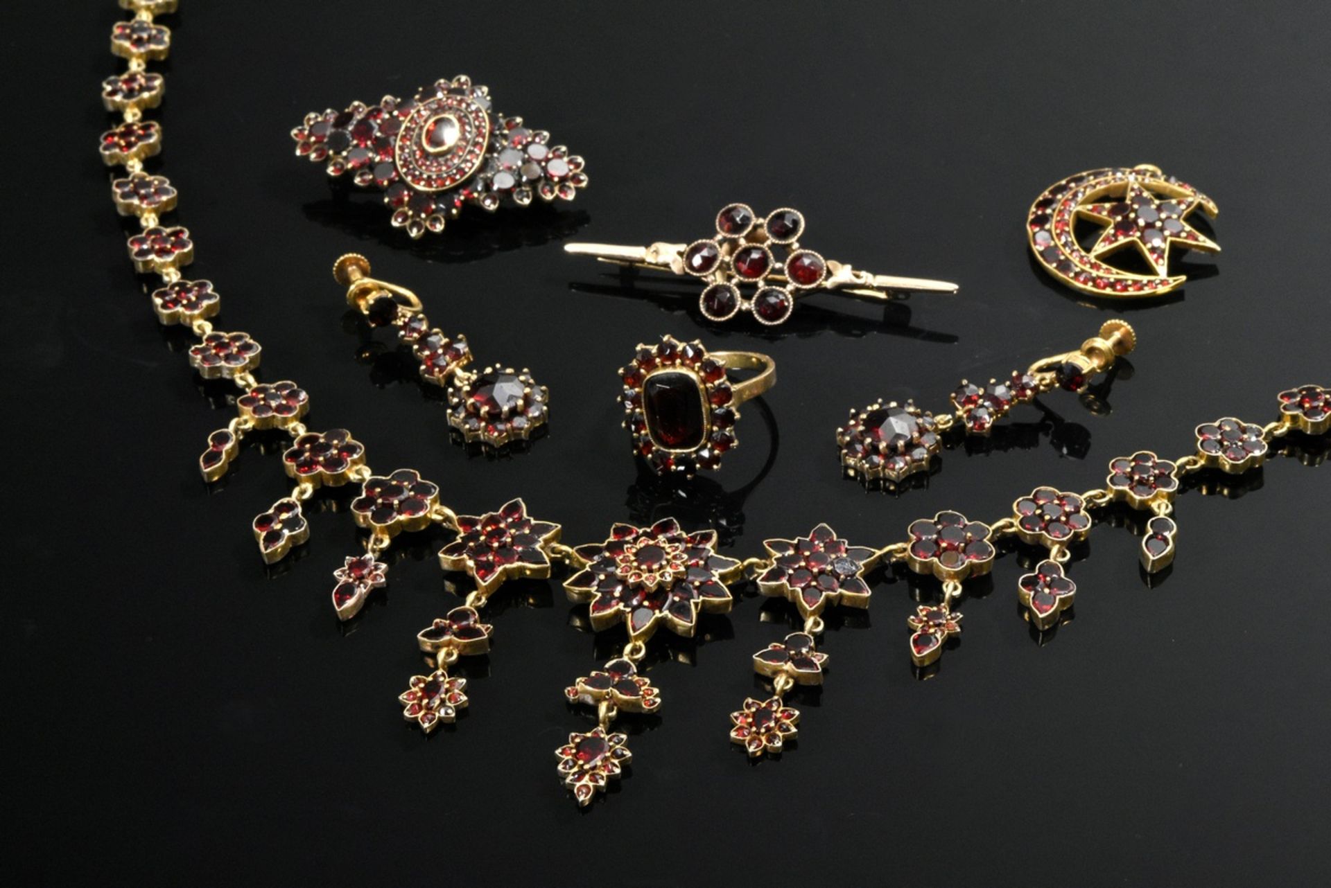 7 Various pieces of garnet jewelry: tombac necklace (l. 47cm), needle (l. 4.3cm), pair of earrings 