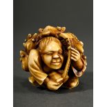 Ivory okimono in ball shape ‘Shamisen player with toads’, patinated, Japan Meiji period, around 190