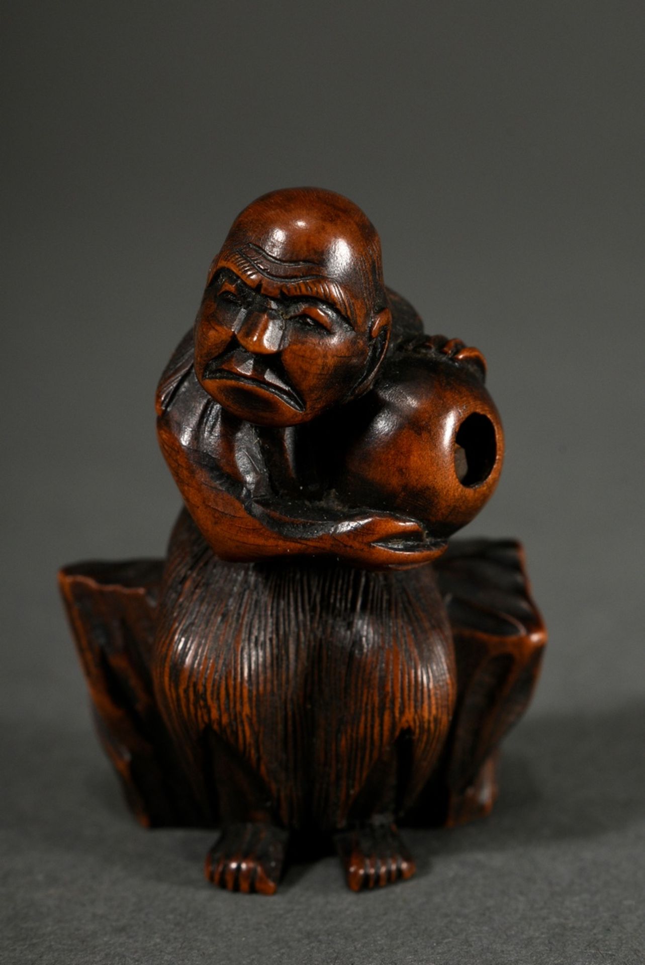 Boxwood netsuke "Fisherman on rock with ball (?)", movable contents, Himotoshi of different sizes, 