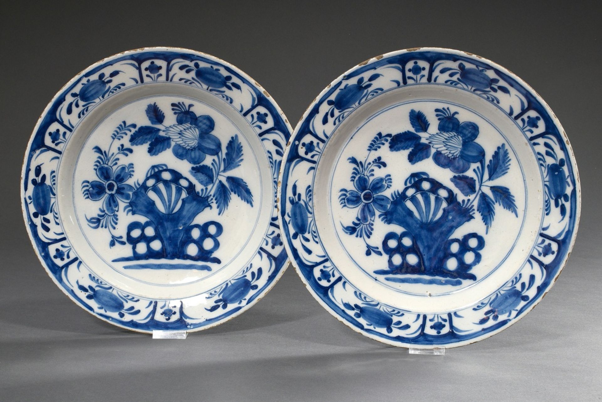 Paar holländische Fayence Teller mit floralem Blaumalerei Dekor „Fels und Blumen" nach asiatischem 