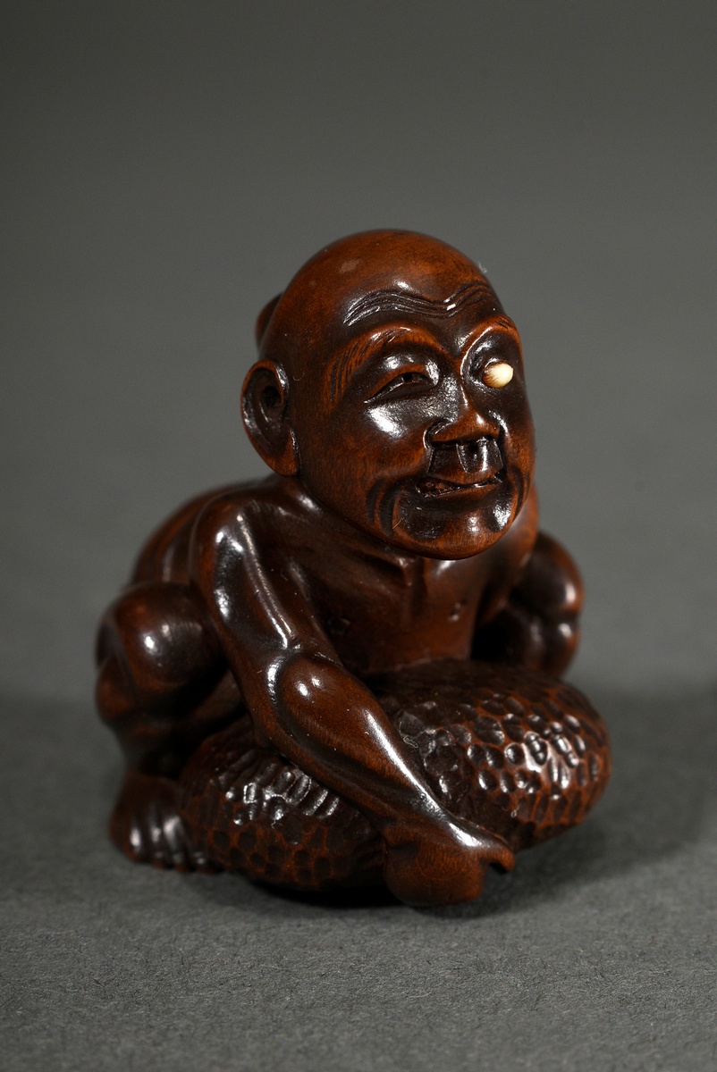 Boxwood netsuke "Blind stone lifter", eye inlaid in bone, on inlaid bone cartouche, sign. Gyokkei, 