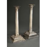 A pair of large silver-plated column candlesticks with pierced composite capitals and stepped bases
