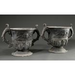 Pair of cast lead garden vases with sculptural eagle handles and angel head reliefs on the wall, h.
