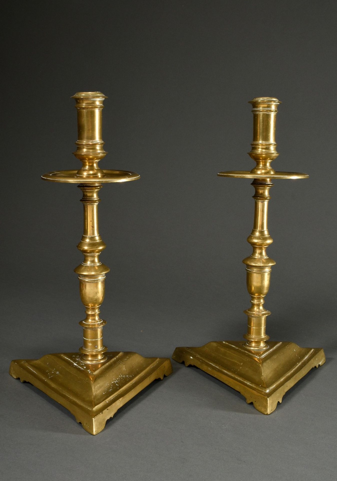 Pair of large yellow cast iron Heemskerk candlesticks with baluster stem and wide drip pans on a ra
