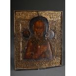 Russian icon "Saint Nicholas" under a florally embossed brass oklad, egg tempera/chalk ground on wo