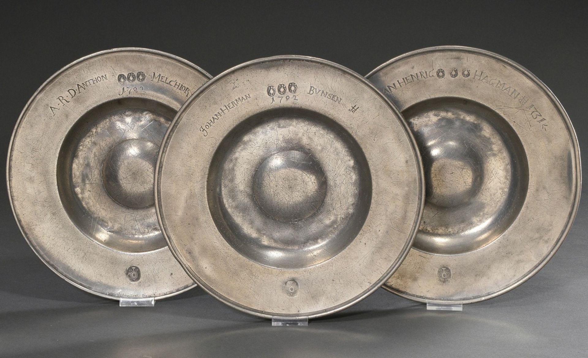 3 pewter wide rim plates with a humped centre, each dated and marked on the rim "A.R.D. Anthon Melc