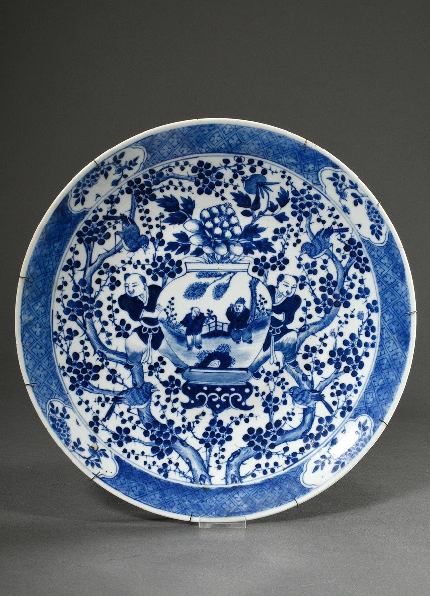 Round platter with rich blue-painted decoration "Two boys with vase on prunus branch background wit