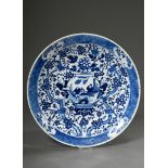 Round platter with rich blue-painted decoration "Two boys with vase on prunus branch background wit