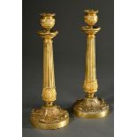 A pair of fine gilt bronze candlesticks with sculpted leaf cuffs and friezes and a brass shaft over