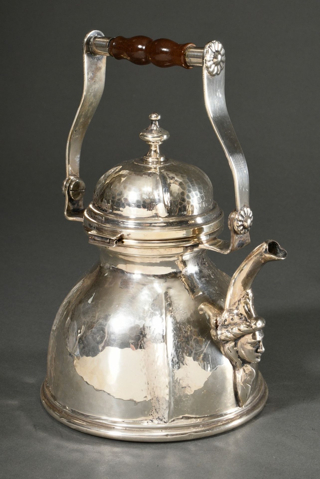 Water kettle after an old model with hinged lid, movable wooden handle and sculpted head on the spo