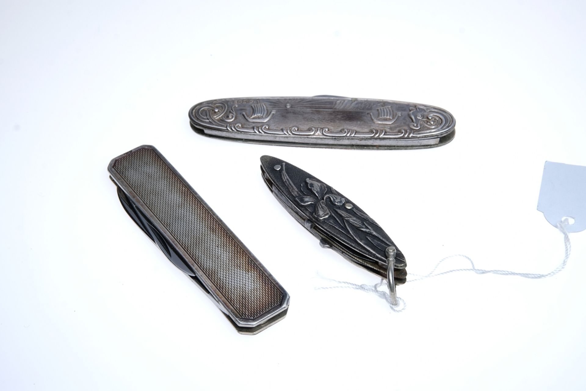 Three pocket knives in various shapes and patterns: