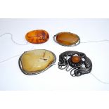 Four amber brooches: