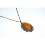 Amber pendant in fine openwork setting, oval shape, 935 silver, hallmarked, on chain, length 65 cm