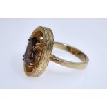 Ring with oval cut stone (7x11mm), probably smoky quartz, set in four double prongs, chiselled side