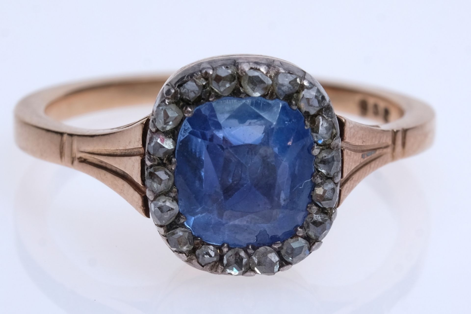 Rose gold ring with blue gemstone, flanked by 17 brilliant-cut diamonds, 17 of 18 brilliant-cut dia