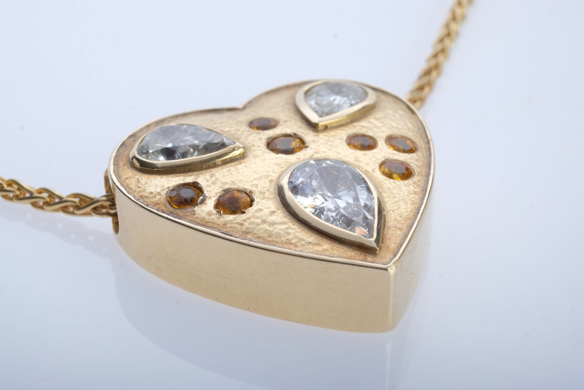 An antique heart pendant set with three old-cut diamonds, white, with inclusions, and seven citrine