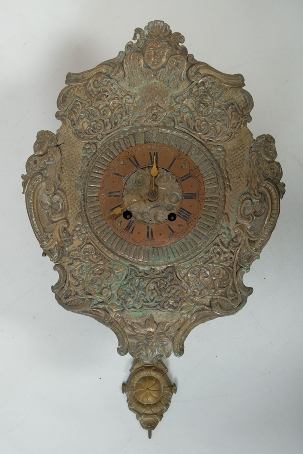 Wall clock with brass dial and angel decorations.