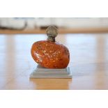 Amber stone, Findling on plinth, coin from 1923 on top, "1 Gulden", total height 9 cm, amber 4.5 x 