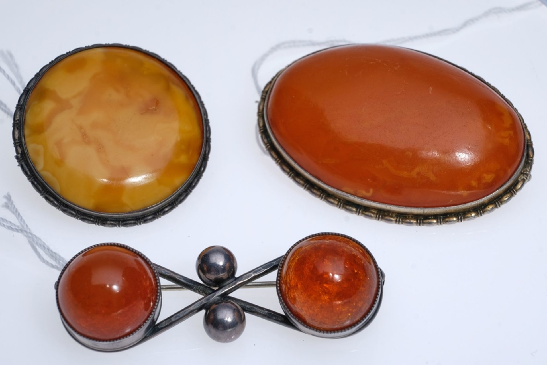 Three amber brooches: