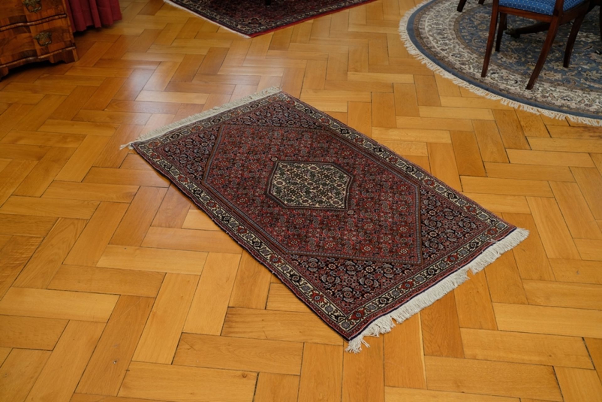 Teppich in leichten Rot-/Brauntönen, Rauten-Design, Fransen