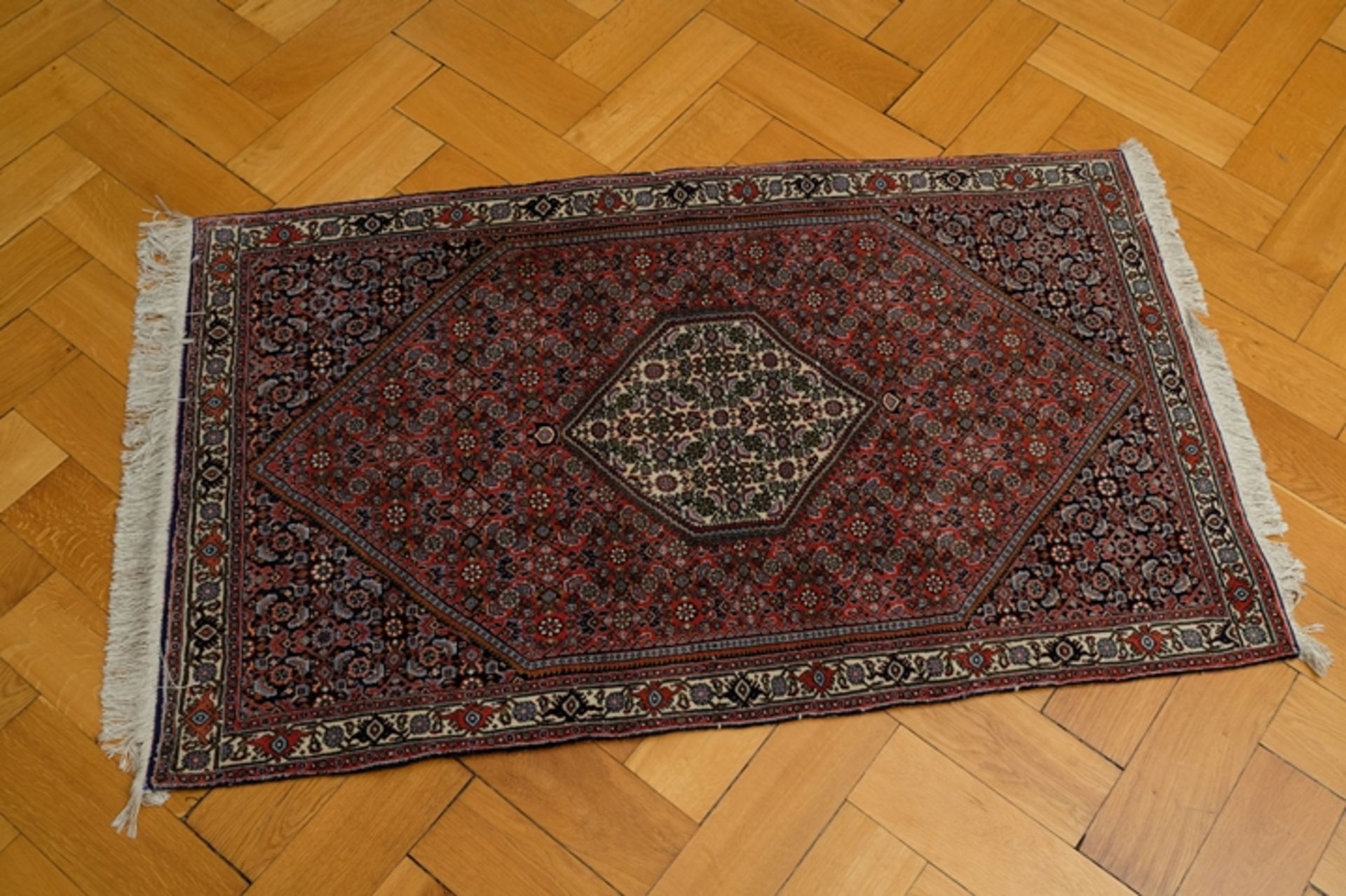 Teppich in leichten Rot-/Brauntönen, Rauten-Design, Fransen - Bild 2 aus 2