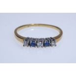 Ring set with three brilliant-cut diamonds and two sapphires, set in prongs, yellow gold 585, hallm