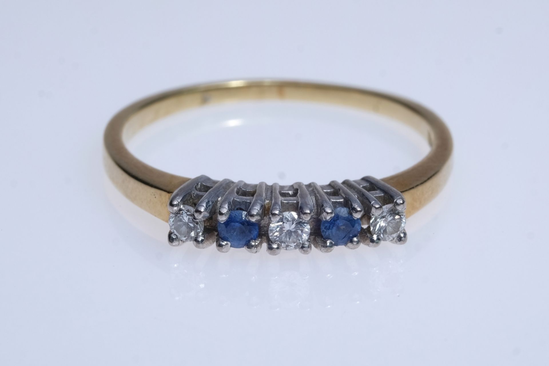 Ring set with three brilliant-cut diamonds and two sapphires, set in prongs, yellow gold 585, hallm