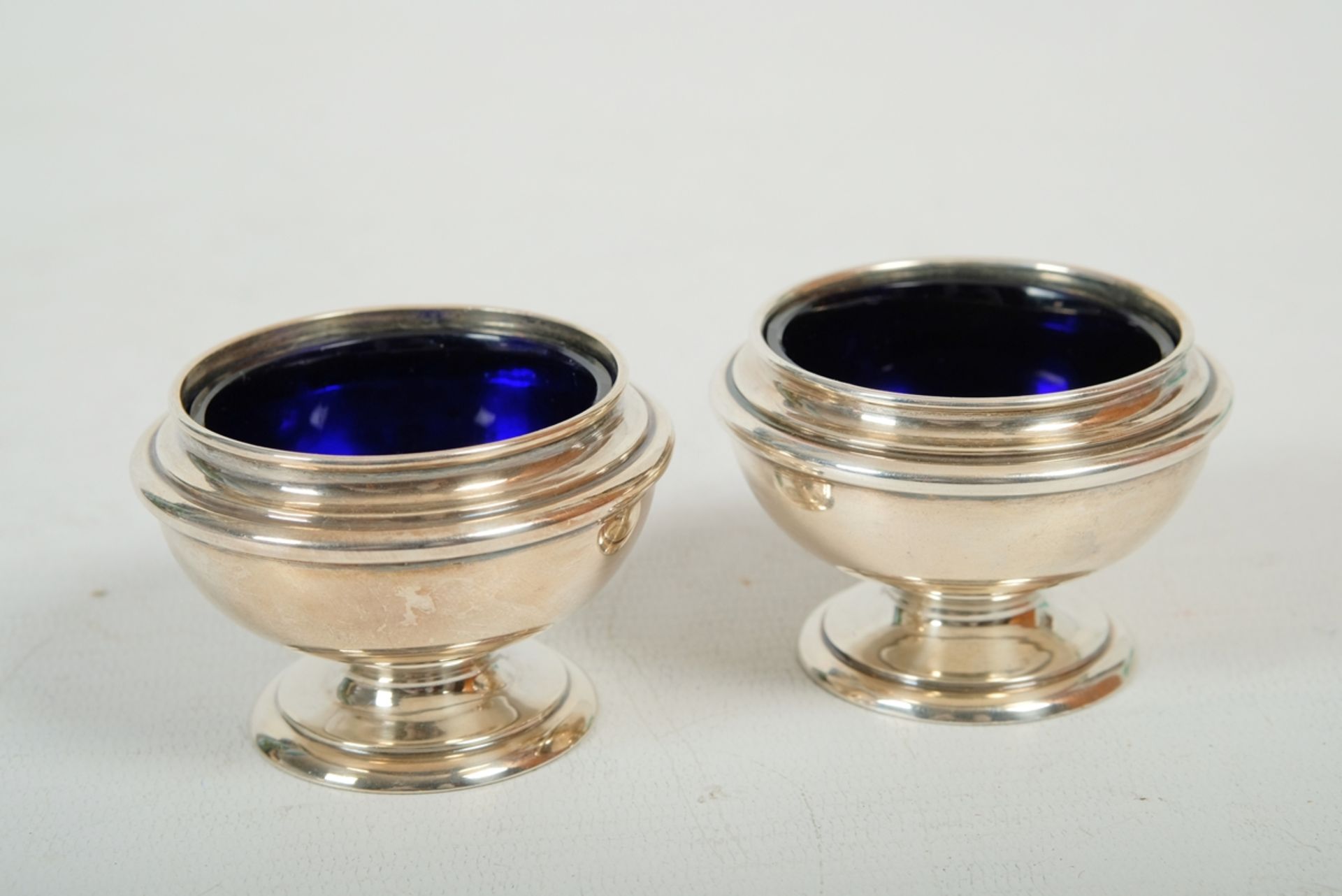 Zwei Senf-Schalen mit Fuß, jeweils mit Kobaltglas-Einsatz, Durchmesser 6,5 cm.