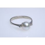 Ring with a cultured pearl set in the centre (diameter 7 mm), flanked by two small diamonds, 750 wh