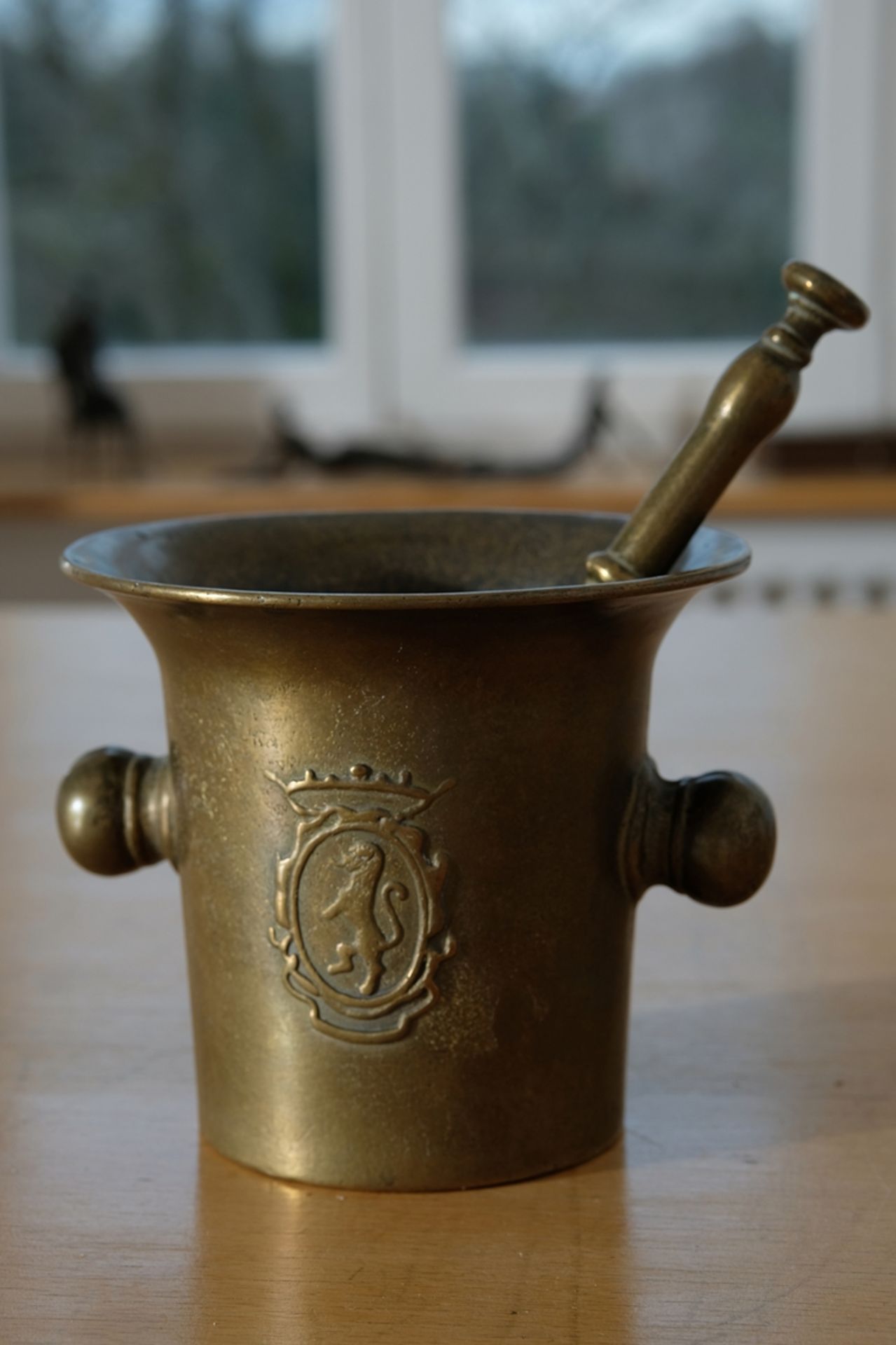 Mortar with pestle made of brass, antique, decorated with coat of arms. 