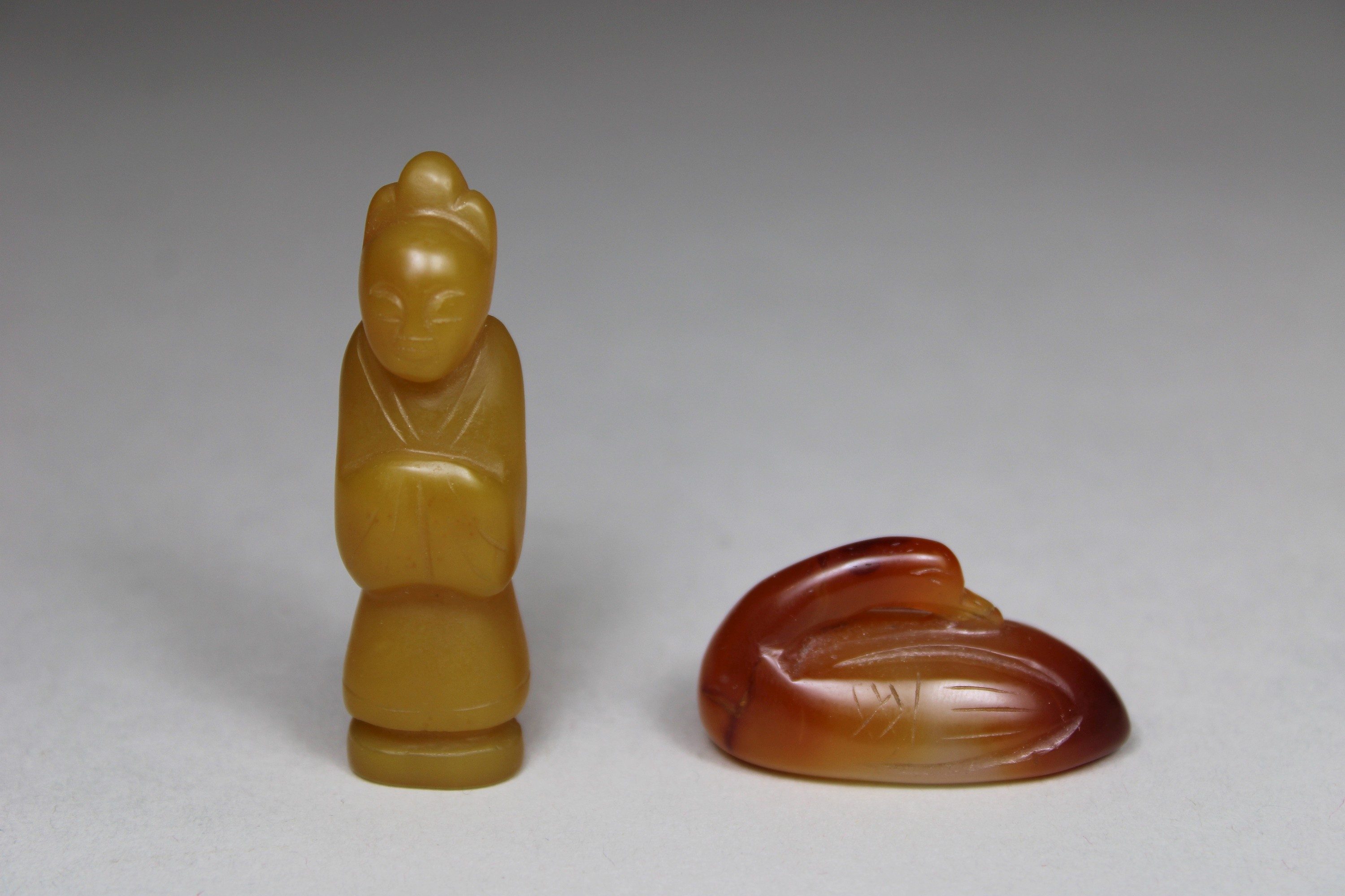 Vier Schnitzereien, China, 1 Beamter aus gelben Jade, H.: 5,5 cm, 1 Ente aus Rote-Achat, L.: 3,9 cm - Image 2 of 4