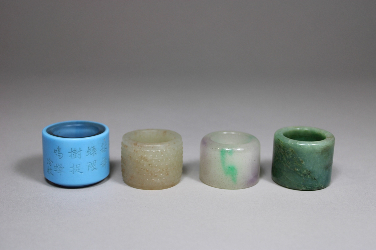 Vier Daumen-Ringe, China, 2 aus Jade, 1 weißer Jade, 1 aus Doppelschicht-Glas mit Gedicht, wohl Qin